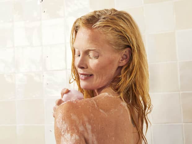 Woman using soap in shower