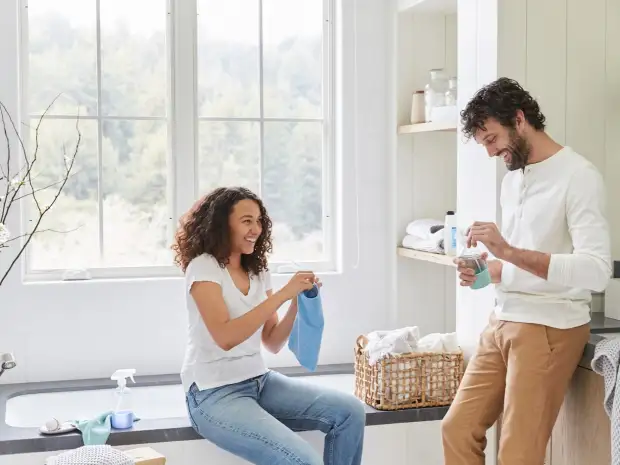 Man and woman smiling in bathroom / laundry room