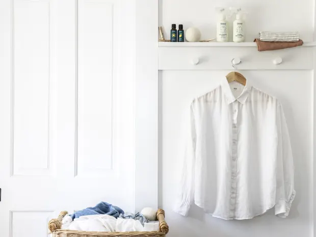 white clean shirt hanging on the wall with laundry products