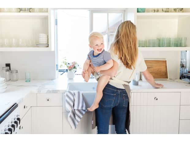 Mom and baby laughing in the kitchen near the sink