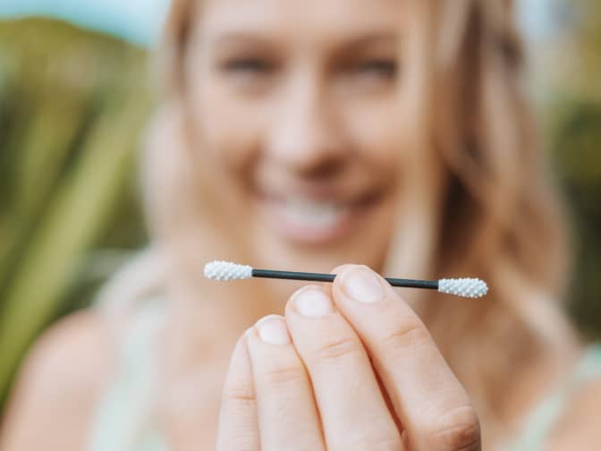 Image of a woman holding a reusable cotton swab