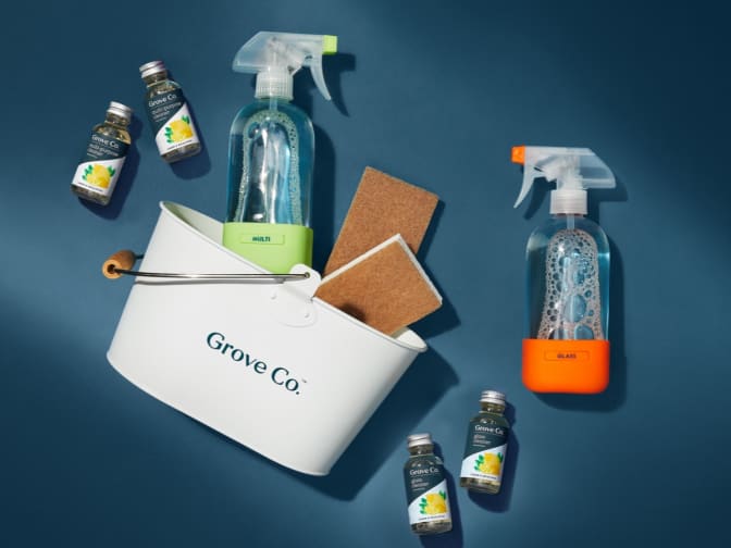 Flat lay of Grove caddy, glass spray bottles, sponges, and cleaning concentrate