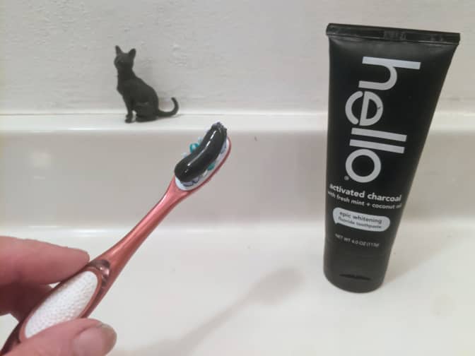 Photo of toothbrush with Hello activated charcoal toothpaste on it