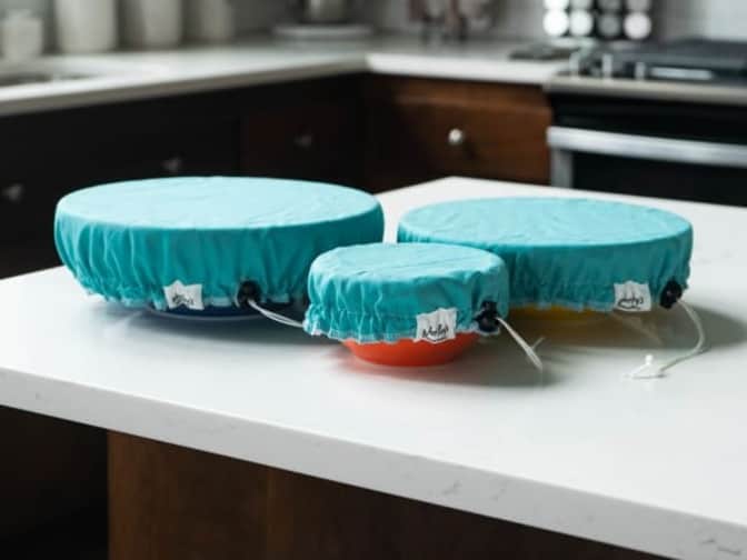 Image of Marley's Monsters aqua bowl covers in different sizes on bowls on top of counter