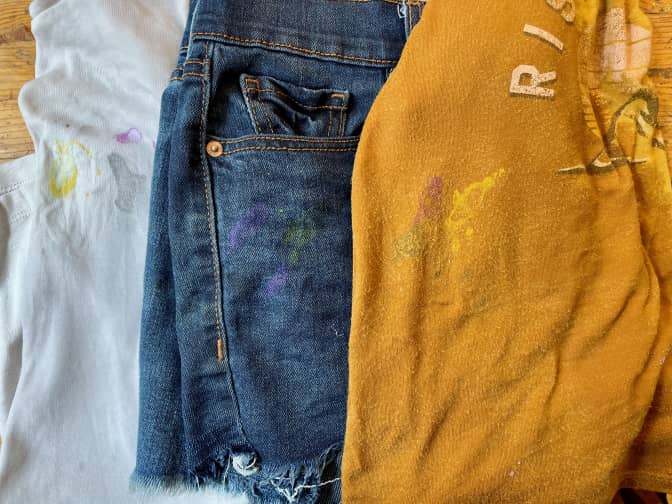 paint stains on three different pieces of clothing looking better (but not gone) after cleansing.