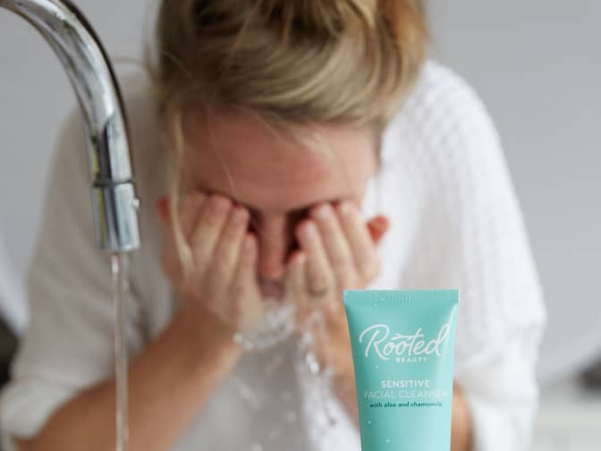 Photo of woman washing face with Rooted face wash