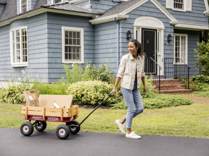 Image of woman pulling wagon outside of home