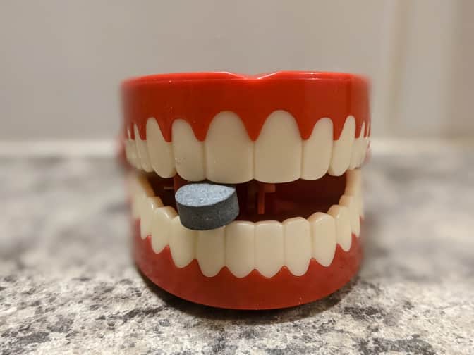 Chattering teeth toy with toothpaste tablet between teeth