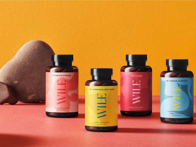 Image of 4 bottles of Wile supplements on red table next to stones