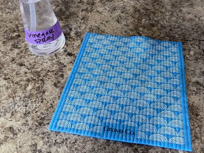 Clean kitchen counter with a Grove European dish cloth and a bottle of vinegar cleaning spray