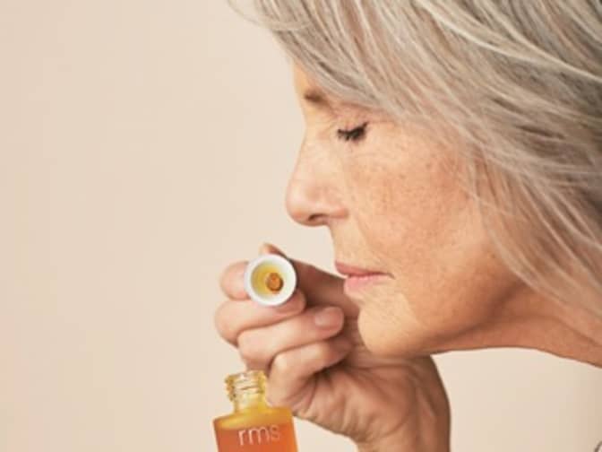 Photo of woman sniffing skincare product