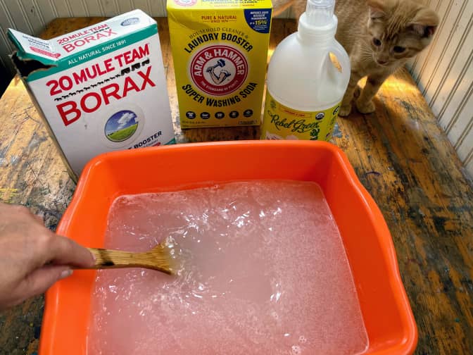 Photo of borax cleaning solution in container being stirred