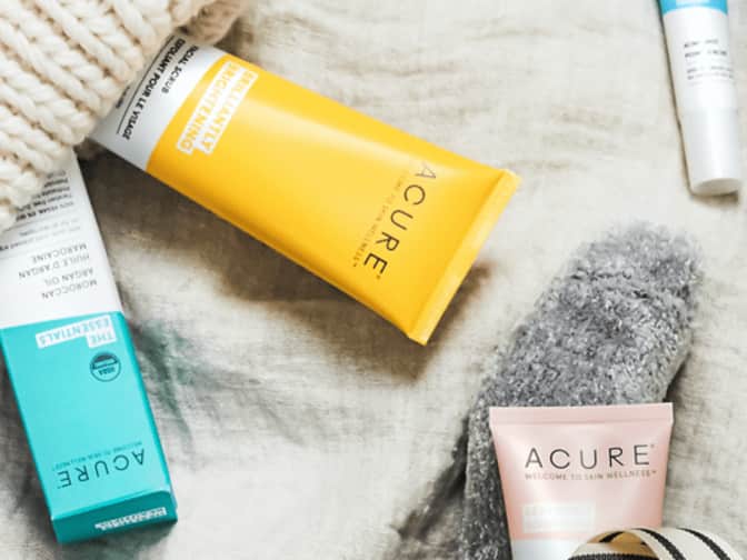 Photo of Acure skinscare products lying on table diagonally next to each other