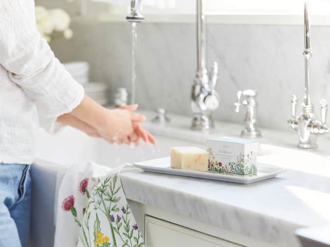 woman washing hands with grove bar soap over the sink