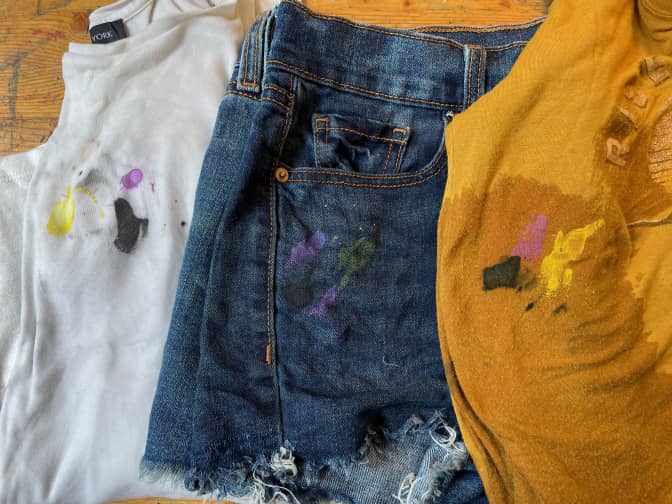 three paint-splattered clothing items after they've been blotted and rinsed.