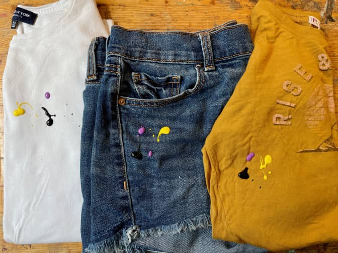 three clothing items with paint splattered on them
