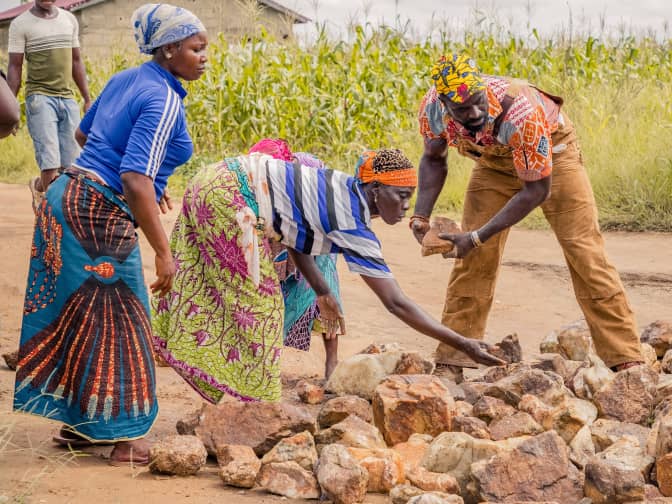 Photo of group of three people picking up rocks