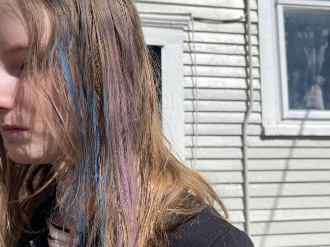 a child with blue and pink hair chalk in her blonde hair