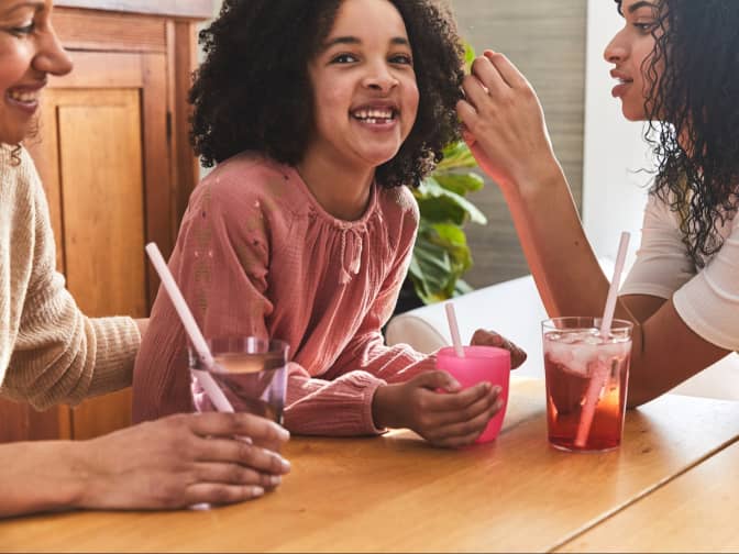 Image of family around a table with drinks and straws