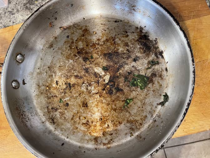 Image of a stainless steel pan with burnt on food. 