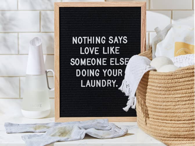 Image of a letter board next to some laundry saying "Nothing says love like someone else doing your laundry."