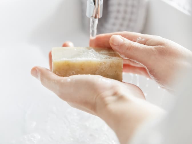 Person washing hands with Grove bar soap 