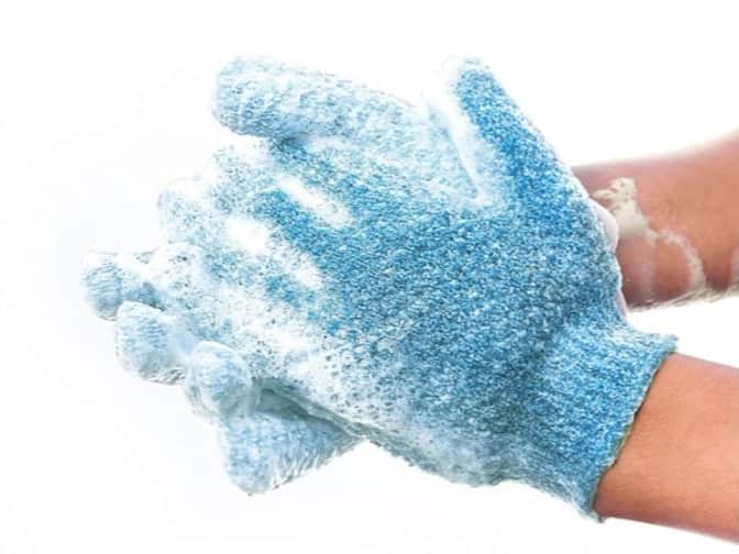 Image of someone wearing soapy exfoliating gloves
