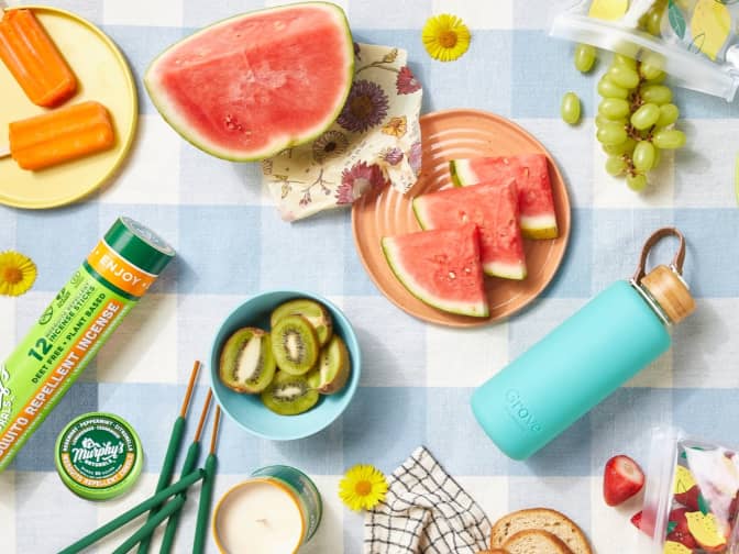 Image of picnic blanket with watermelon, popsicles, grapes, kiwi, Murphy's incense sticks, and Grove water bottle.