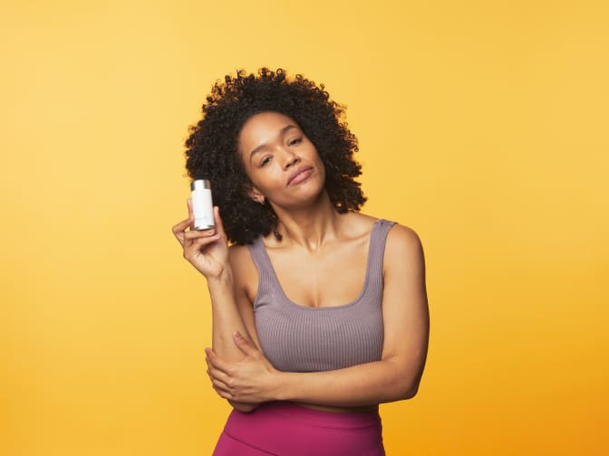 Photo of woman holding product against yellow background