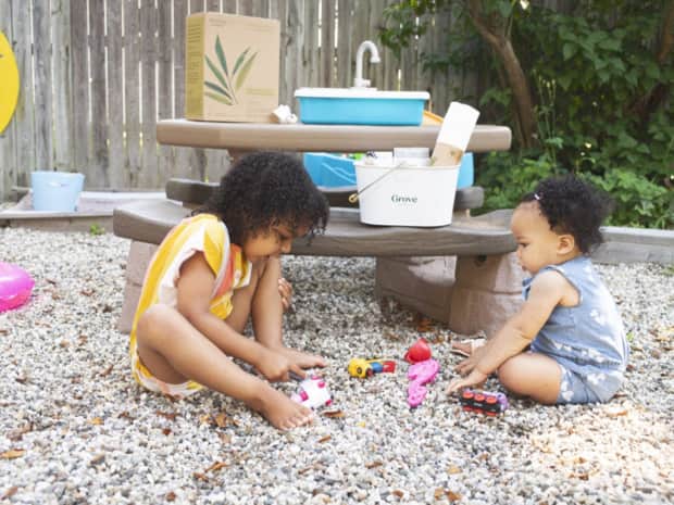 Image of two kids playing outside with toys