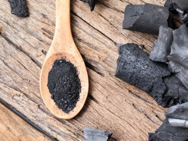 Image of activated charcoal powder on a wooden spoon