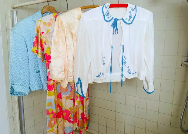 Image of clothing hanging in a bathroom.