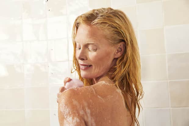 Woman using soap in shower