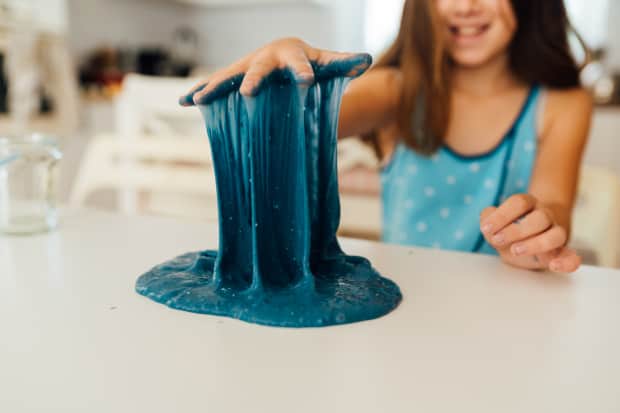 Image of a girl playing with blue slime.