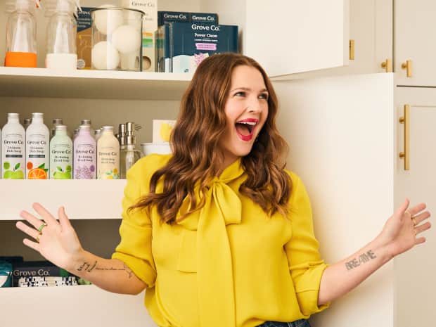 Drew Barrymore standing against a kitchen backdrop 