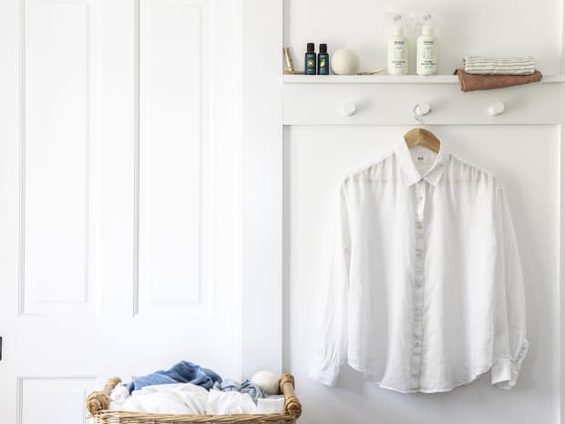 white clean shirt hanging on the wall with laundry products