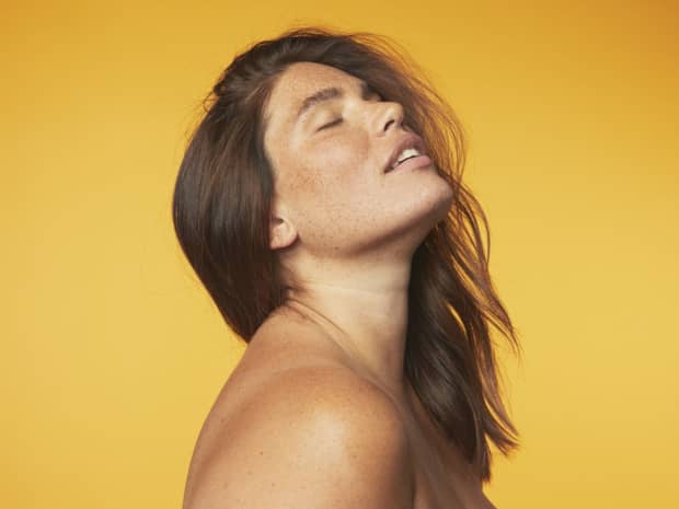 Woman with eyes closed against yellow background