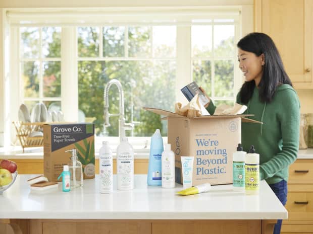 woman in kitchen opening a box of Grove products that just arrived