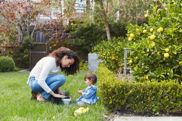 Woman and child in garden with plant in pot
