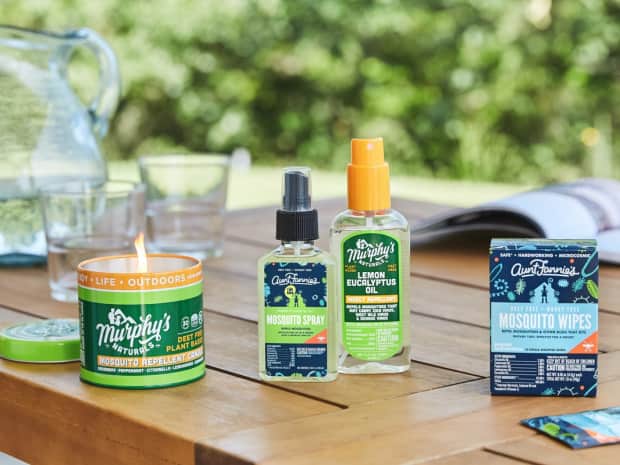 Murphy's Naturals and Aunt Fannie's mosquito products on wooden picnic table with glasses in the background