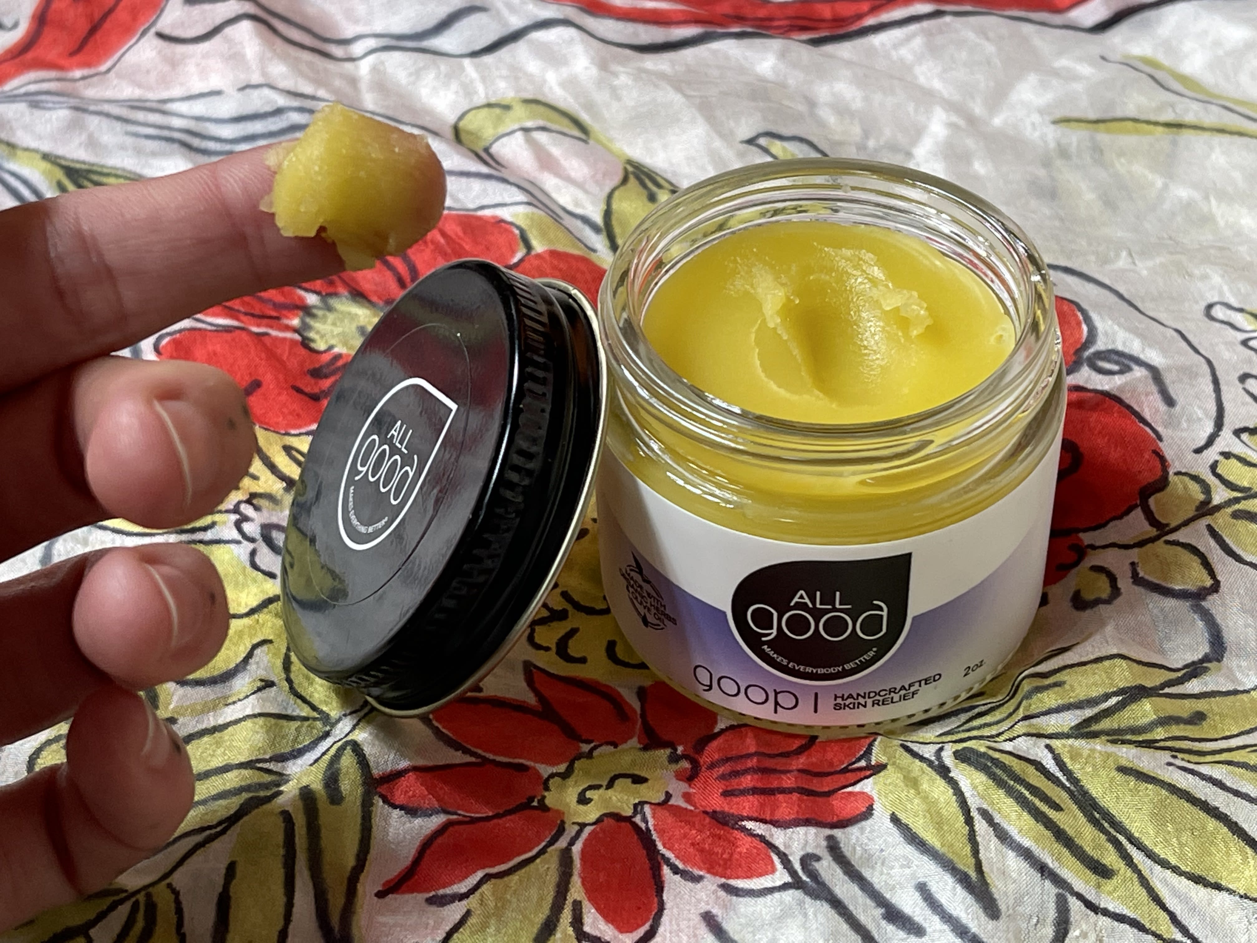 someone dipping their finger into an open jar of All Good Goop